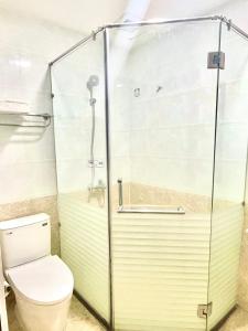 ein Bad mit einem WC und einer Glasdusche in der Unterkunft Nhu Y Hotel in Ho-Chi-Minh-Stadt