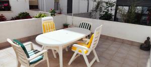 a white table and four chairs on a patio at Somos Mar in Pamplona