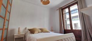 a white bedroom with a bed and a window at Somos Mar by Clabao in Pamplona