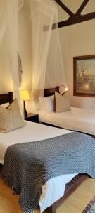 1 dormitorio con 2 camas con mosquiteras en Thornwood, en KwaNibela