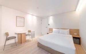 a bedroom with a bed and a desk and a table at Aank Hotel Incheon Bupyeong in Incheon