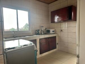 una cocina con fregadero y microondas. en appartements meublés à Logbessou en Douala