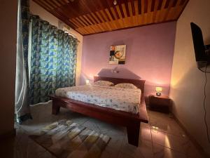 1 dormitorio con cama y cortina azul en appartements meublés à Logbessou, en Douala