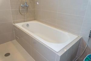 a white bath tub in a tiled bathroom at A2J Luxury Uptown 3BR Suite Near Uptown Mall in Manila