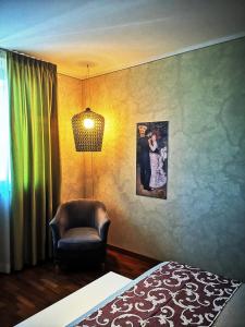 een slaapkamer met een stoel en een foto aan de muur bij ALBERGO BALDAZZI 1916 in Zavattarello