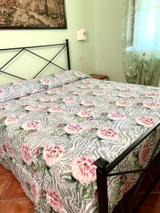 een slaapkamer met een bed met roze bloemen erop bij Agriturismo il Portico in Capalbio