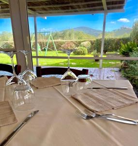 einen Tisch mit Weingläsern und Servietten und Aussicht in der Unterkunft Agriturismo il Portico in Capalbio