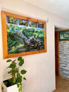 a painting on the wall of a room with a plant at Guest House Plitvice Waterfall in Plitvička Jezera