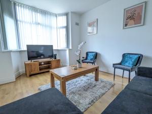 a living room with a tv and a table and chairs at Pass the Keys Spacious Comfortable 3 Bedroom House in Birmingham