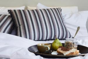 uma bandeja com um prato de comida numa cama em Aeon Suites - Adults Only em Pirgos