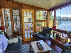 a living room with a view of a lake at Hebergement Cerfs-Tifie fermette in Saint-Félix-d'Otis