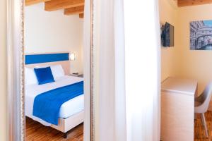 a mirror in a bedroom with a bed and a desk at Hotel Autoespresso Venice - Atika & Atif in Marghera
