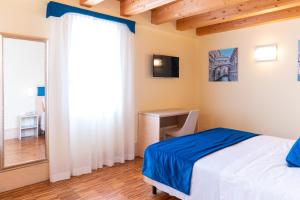 a bedroom with a bed and a desk and a window at Hotel Autoespresso Venice - Atika & Atif in Marghera