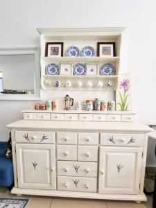 a white dresser with blue and white dishes on it at Mossy Forest Family Retreat, Kea Farm Brinchang in Brinchang