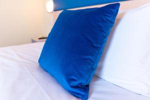 a blue pillow sitting on top of a bed at Hotel Autoespresso Venice - Atika & Atif in Marghera