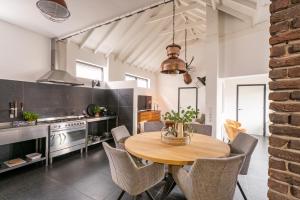 a kitchen and dining room with a wooden table and chairs at Villa La Chatelaine in Egmond aan Zee