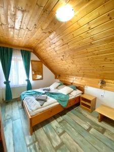 a bedroom with a bed and a wooden ceiling at Guest House Plitvice Waterfall in Plitvička Jezera