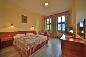 ein Hotelzimmer mit einem Bett und einem TV in der Unterkunft Villa Alexandra in Świnoujście