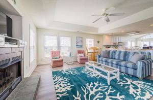a living room with a blue couch and a fireplace at Shell Town in Nags Head