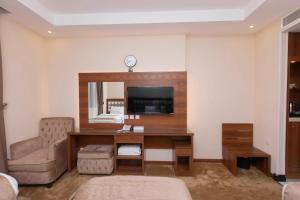 Habitación de hotel con escritorio y espejo en فندق منار التوحيد 2, en La Meca