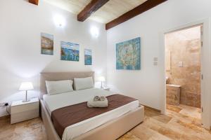 ein weißes Schlafzimmer mit einem Bett und einer Dusche in der Unterkunft Designer HOME with COMFY SOFA in central Valletta by 360 Estates in Valletta