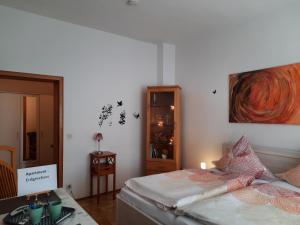 Un dormitorio con una cama con una mesa y una pintura en 3 x Ferien- & Monteurwohnungen Koenen nah am Westfield Centro en Oberhausen