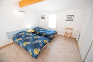 een slaapkamer met 2 bedden en een stoel bij Résidence les Trémières in Bourcefranc +6 foto's