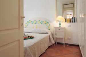a bedroom with a bed and a table with a lamp at Casa Olivastra in Porto Cervo