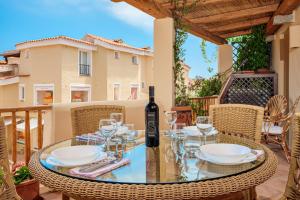 a glass table with a bottle of wine on a patio at Casa Olivastra in Porto Cervo