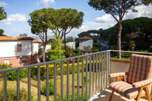 a balcony with two chairs and a fence at Villetta dei Pini in Scarlino