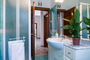 a bathroom with a sink and a potted plant at Villetta dei Pini in Scarlino +26 photos