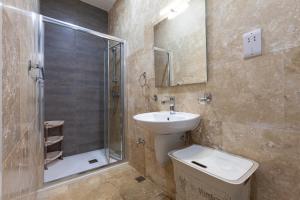 ein Badezimmer mit Waschbecken, Toilette und Dusche in der Unterkunft Designer HOME with COMFY SOFA in central Valletta by 360 Estates in Valletta