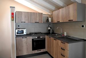 a kitchen with wooden cabinets and a sink and a microwave at La Stalletta in Menaggio