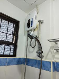 a shower in a bathroom with a blow dryer at YellowPad Hotel (SM-Eco) in Davao City