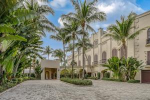 a courtyard with palm trees in front of a building at Seashells and Sunshine Marco Beach Ocean Resort 1105 in Marco Island