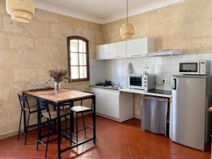 cocina con mesa y nevera en "Le central" Appart Arles en Arlés