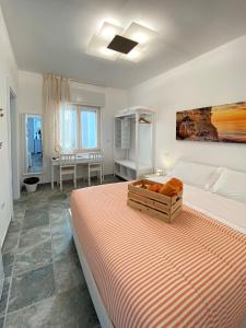 a white bedroom with a large bed and a table at Lulía bed&breakfast in Otranto