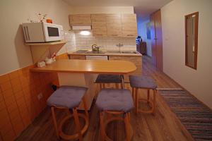 a small kitchen with a wooden table and stools at Centrum Karkonoszy in Karpacz