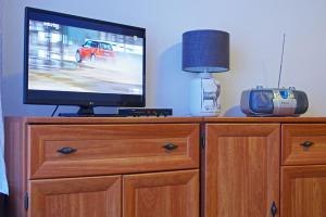 a tv sitting on top of a dresser with a radio at Centrum Karkonoszy in Karpacz