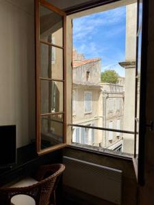 una ventana abierta con vistas a un edificio en "Le central" Appart Arles en Arlés