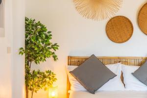 ein Schlafzimmer mit einem Bett und einer Topfpflanze in der Unterkunft Le Balcon, Haad Yao. in Haad Yao