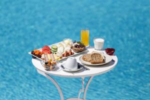 ein Tablett mit Frühstücksspeisen auf einem Tisch am Wasser in der Unterkunft Anamar Blu in Ornos