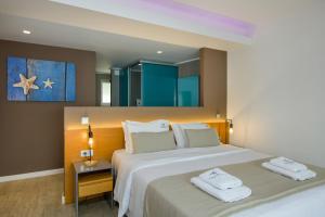 a bedroom with a large bed with towels on it at Balos Beach in Kissamos