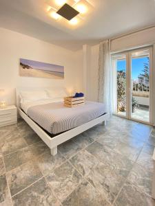 - une chambre avec un lit et une grande fenêtre dans l'établissement Lulía bed&breakfast, à Otrante