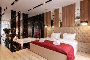 a bedroom with a large bed and a bath tub at ARISTO Jacuzzi Hotel in Lviv