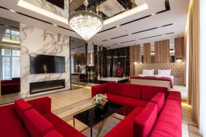 a living room with a red couch and a fireplace at ARISTO Jacuzzi Hotel in Lviv