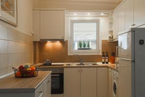 a small kitchen with a sink and a window at Mon Repos deluxe apartment in Corfu