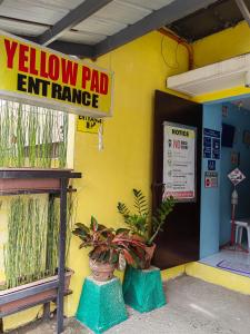 een geel geschilderd gebouw met een gele pad uitgang garage bij YellowPad Hotel (SM-Eco) in Davao City