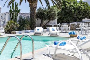 einen Pool mit weißen Stühlen und einem Pool in der Unterkunft Anamar Blu in Ornos