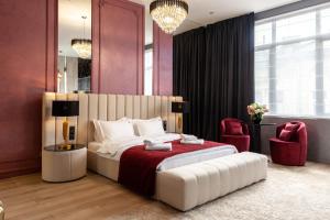 a bedroom with a large bed and two red chairs at ARISTO Jacuzzi Hotel in Lviv +83 photos